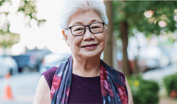 Portrait of a smiling patient using Optune Lua device.