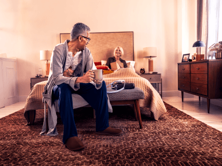 Patient sitting on a couch while using Optune Lua device for metastatic non-small cell lung cancer.
