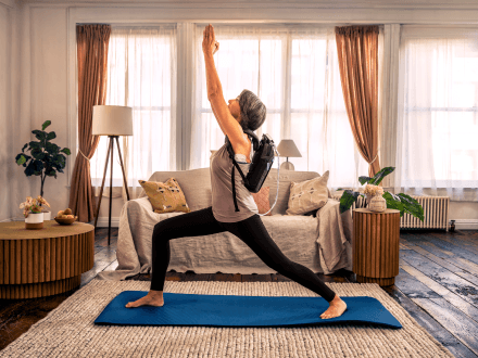 Patient performing yoga while wearing the Optune Lua device, illustrating MyNovocure support services.