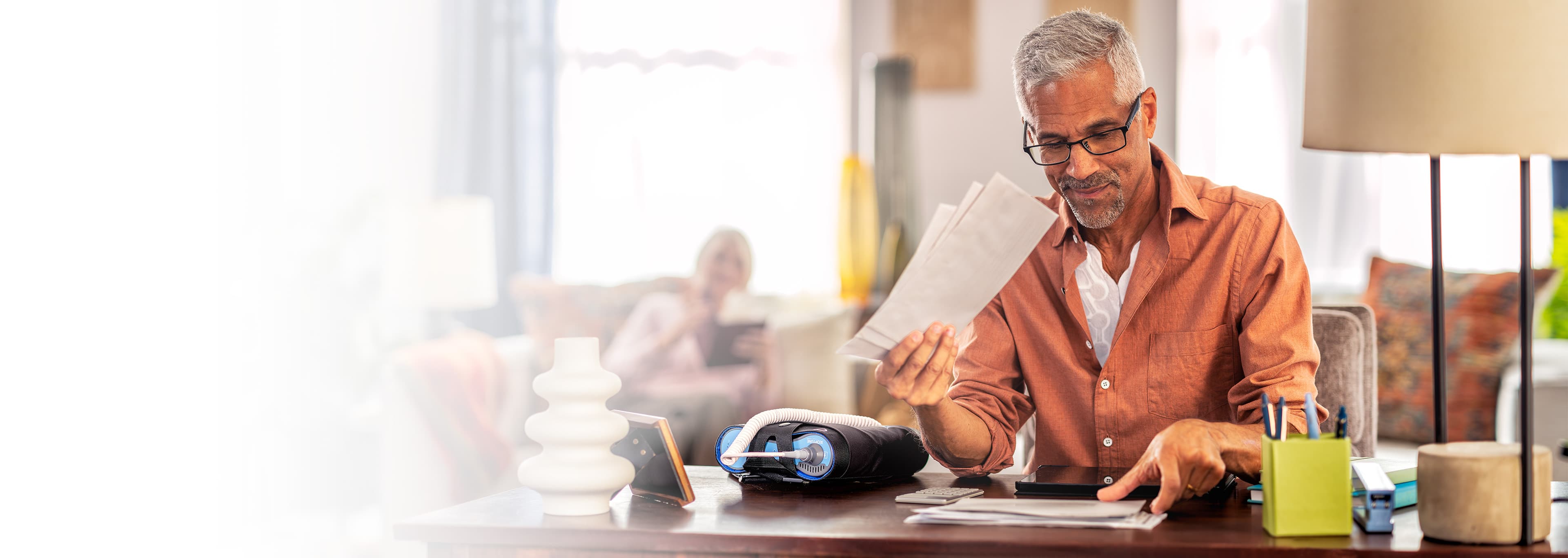 Patient at desk with Optune Lua device®